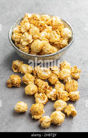 Sweet caramel popcorn in bowl on gray table. Stock Photo