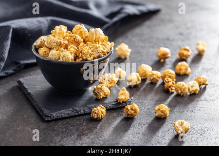 Sweet caramel popcorn in bowl on black table. Stock Photo