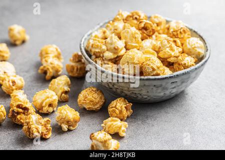 Sweet caramel popcorn in bowl on gray table. Stock Photo
