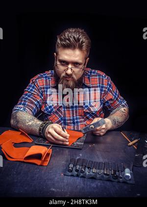 Leather Artist being keen on his buisness at studio Stock Photo