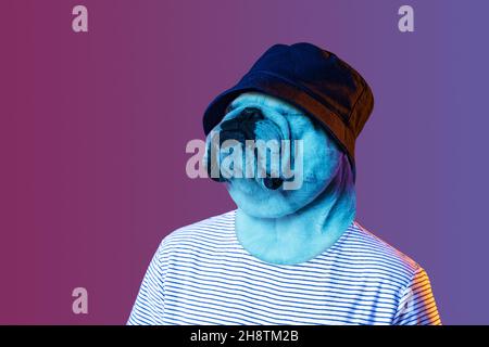 Contemporary artwork, conceptual collage. Young stylish man in hat headed by dog head isolated on purple background in neon. Surrealism Stock Photo