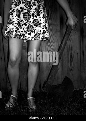 Black and white photograph of young girl holding medieval axe Stock Photo