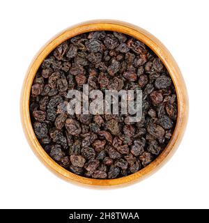 Zante currants, in a wooden bowl. Small raisins, also known as Corinth raisins or simply currants. Dried fruits of the small, sweet, seedless grapes.