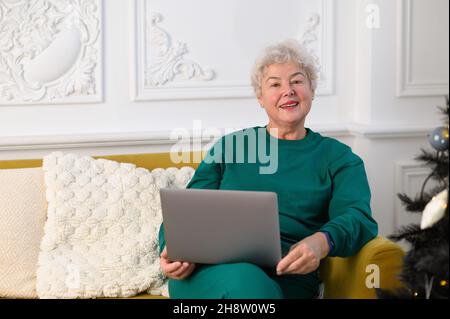 Senior mature older woman watching business training, online webinar on laptop computer remote working or social distance learning from home Stock Photo