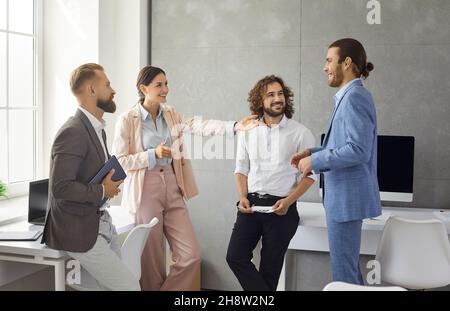 Smiling multiracial colleagues communicate brainstorm at workplace Stock Photo