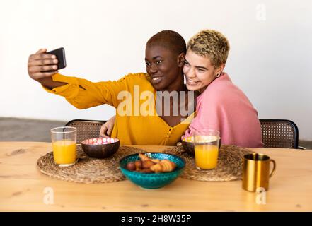 Multiethnic couple taking a selfie while having dinner Stock Photo