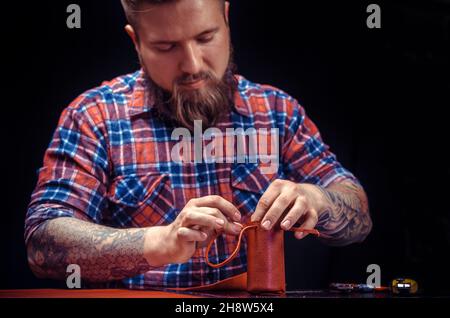 Craftsman produces leather workpiece at the workplace Stock Photo