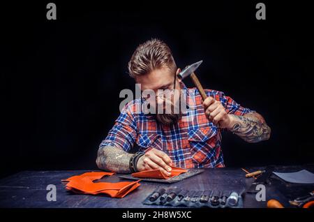 Worker of leather creating new leatherwork at studio Stock Photo