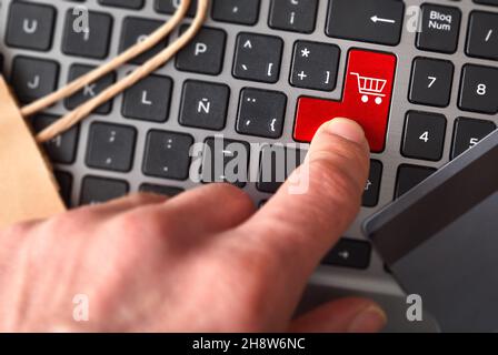 Finger pressing laptop key to order purchase order. Top view Stock Photo