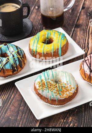 Delicious donuts decorated with different decorations on wooden table Stock Photo