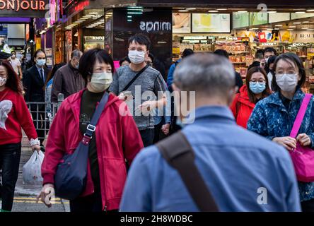 Hong Kong, China. 02nd Dec, 2021. Pedestrians are seen wearing face masks as a preventive measure against the spread of coronavirus as they walk through a zebra crossing in Hong Kong. The city of Hong Kong is on high alert as a heavily-mutated new Covid-19 variant known as the Omicron variant has been detected from a passenger traveling from South Africa. (Photo by Miguel Candela/SOPA Images/Sipa USA) Credit: Sipa USA/Alamy Live News Stock Photo