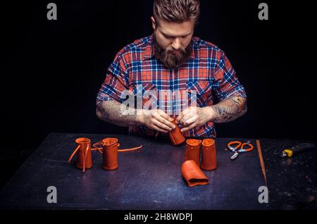 Tanner of leather cutting out leather goods in his leather studio Stock Photo