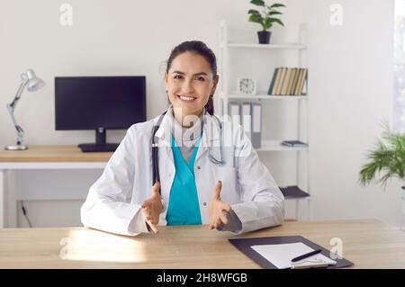 Smiling woman doctor talk on webcam call with patient Stock Photo