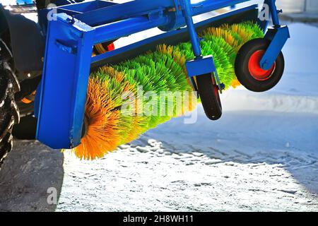 Industrial brush on tractor to clean streets from snow close-up. New attachments for sweeping and cleaning sidewalk of city in winter. Background. Stock Photo