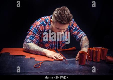 Leather Artist making quality products at his shop Stock Photo