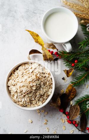 Old fashioned rolled oats in a white bowl on holiday background, selective focus Stock Photo