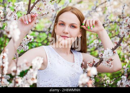 Close up portrait of a young blonde woman posing in spring park Stock Photo
