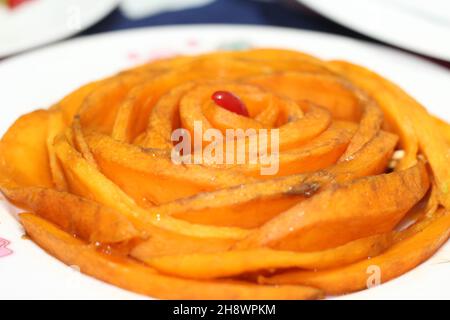 Sliced mango Decoration with Cherry on Plate Stock Photo