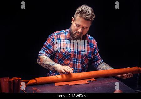 Artist working with leather processing a leather workpiece Stock Photo