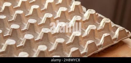 Protective cardboard packaging for storing eggs. Empty biodegradable molded egg box made of paper pulp. Stock Photo