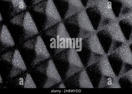 Background made of a macro photo with a smooth diamond-shaped black metal surface with white dots. Stock Photo