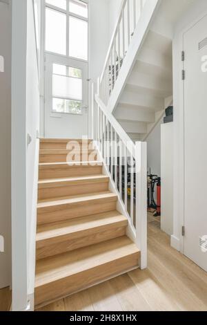 Empty stairway with white railings in luxury apartment with minimalistic interior in daytime Stock Photo