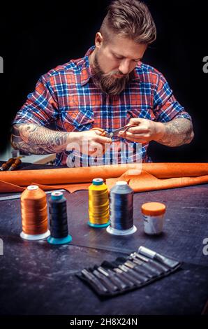 Leather Skinner produce a leatherwork in his work area Stock Photo