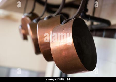 Copper pans hanging in a traditional French kitchen Stock Photo