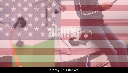 Double exposure of man using smartphone leaning on electric car at charging station with us flag Stock Photo