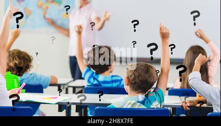 Digital composite of question marks over students with hands raised answering teacher in classroom Stock Photo