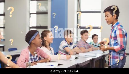 Digital composite of question marks over schoolboy giving presentation in front of friends Stock Photo