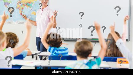 Digital composite of question marks over students with raised hand answering teacher in classroom Stock Photo