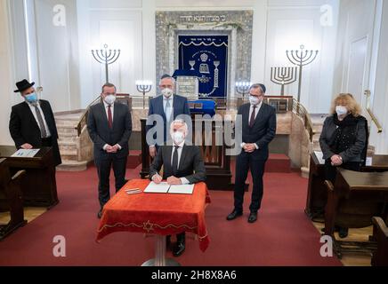 02 December 2021, Baden-Wuerttemberg, Stuttgart: Thomas Strobl (CDU, front), Interior Minister of Baden-Württemberg, signs a 'Stuttgart Declaration' against hatred and incitement at the autumn conference of the Interior Ministers and Interior Senators of the federal states in a synagogue. In the second row are Yehuda Pushkin (l-r), Israelite Religious Community of Württemberg, Boris Pistorius (SPD), Minister of the Interior of Lower Saxony, Joachim Herrmann (CSU), Minister of the Interior of Bavaria, Hans-Georg Engelke, State Secretary in the Federal Ministry of the Interior for Building and H Stock Photo