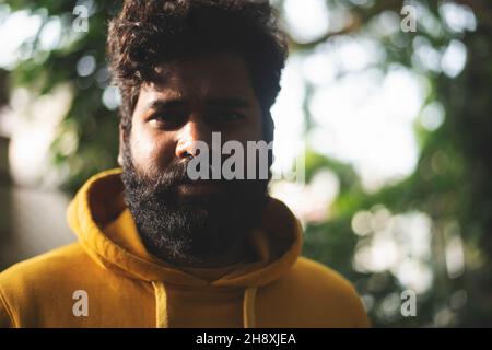 man relaxing in a green public park, Indian male model with green background Stock Photo