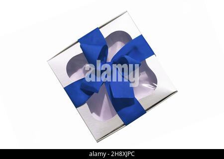 Trendy silver gift box with blue ribbon bow isolated on white background. Stylish metallic present box with transparent window. Contrasting web banner Stock Photo