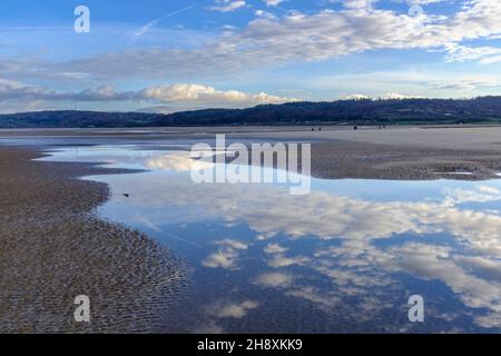 Reflections of vapour trails and clouds in the estuary at Red Warf Bay, Anglesey, North Wales, UK Stock Photo