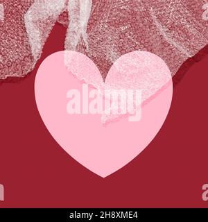 Heart symbol with bubble wrap and copy space against a red background Stock Photo