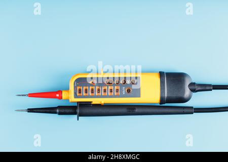 Yellow voltage indicator on a blue background. Free space Testing and verification of electrical networks Stock Photo