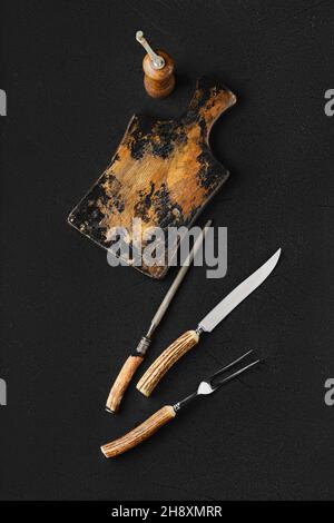 Overhead view of empty vintage wooden cutting board and knife with fork for steak Stock Photo