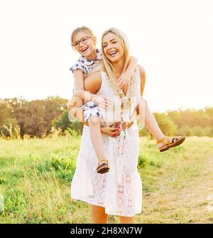 child family outdoor mother woman girl happy happiness lifestyle having fun bonding piggyback Stock Photo