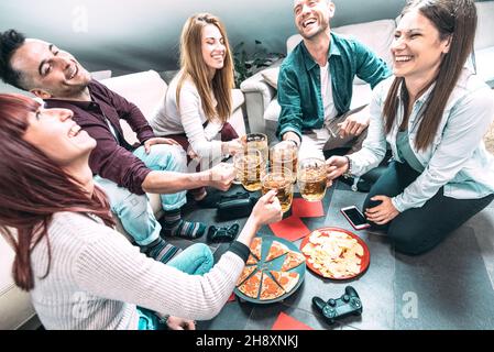 Young millenial friends eating pizza at home after college - Friendship concept with roomates students enjoying time together having fun Stock Photo