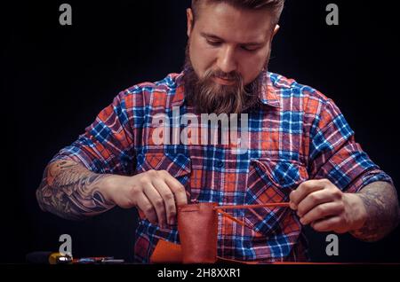 Leather Worker produces leather goods at the leather shop Stock Photo