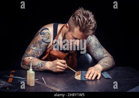Craftsman working with leather cuts out leather goods in the tanner shop Stock Photo