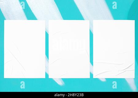 teal mint urban wall with three glued posters Stock Photo