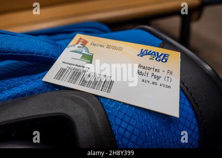 Anacortes, WA USA - circa November 2021: View of a Washington State Ferry ticket sitting on top of a blue suitcase. Stock Photo