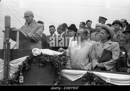 Warszawa, 1946-07-22. Otwarcie mostu Poniatowskiego, odbudowanego po zniszczeniach wojennych. Most powsta³ w latach 1905-1913 wed³ug projektu Mieczys³awa Marszewskiego i Wac³awa Paszkowskiego; autorem architektury by³ Stefan Szyller. W 1944 roku most zosta³ zniszczony przez Niemców. Odbudowany wed³ug projektu Stanis³awa Hempla. Nz. przemawia Komisarz Odbudowy Warszawy in¿. arch. Roman Piotrowski. Wœród zgromadzonych na trybunie honorowej: minister odbudowy Micha³ Kaczorowski (w pierwszym rzêdzie 2P), minister bezpieczeñstwa publicznego Stanis³aw Radkiewicz (2L), minister przemys³u Hilary Minc Stock Photo