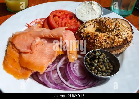 Breakfast plate of smoked salmon, red onions, bagel, capers, tomato and cream cheese, in the United States of America. Stock Photo