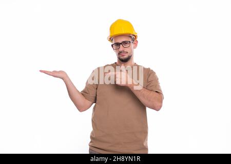 Builder Holding Hand to Side Pointing at It Isolated. Man Construction Worker Sign. Advertisment, Commercial, Business concept Stock Photo