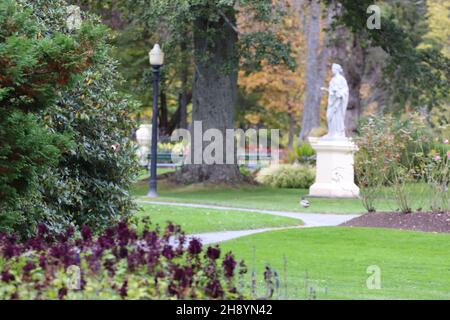 Landscape view of Halifax Public Gardens and a statue of a Roman goddess surrounded by flowers Stock Photo