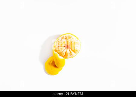Tangerine half peeled with a peel in the shape of a spiral lies on a white background. Isolate. Lifestyle. Close-up. View from above. Horizontal photo. High quality photo Stock Photo